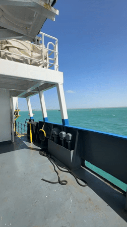 Tugboat passes vessel in calm Colombian waters