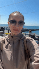 Woman takes selfie at sunny Sochi seaside promenade
