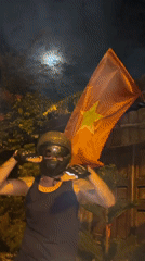 Helmeted rider explores a Vietnamese neighborhood under a full moon