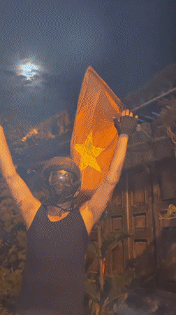 Helmeted rider explores a Vietnamese neighborhood under a full moon