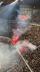 Milan stadium filled with cheering fans, red flares ignited