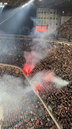 Milan stadium filled with cheering fans, red flares ignited
