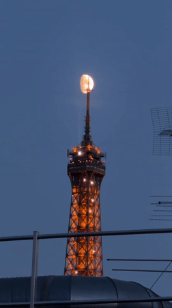 Eiffel Tower glows orange under a deep blue dusk sky