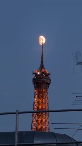 Eiffel Tower glows orange under a deep blue dusk sky