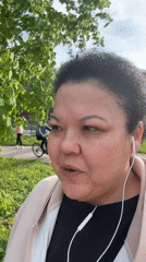 Woman films herself outdoors in park during early morning