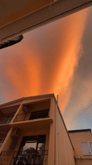Dramatic sunset with orange clouds observed over residential buildings