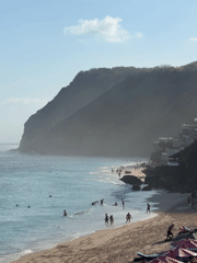 Crowded Kuta Selatan beach below dramatic cliffs, Bali