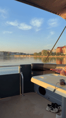 Child in life vest explores calm lake from pontoon boat