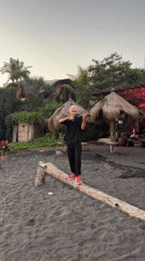 Violinist performs on log at Indonesian beach