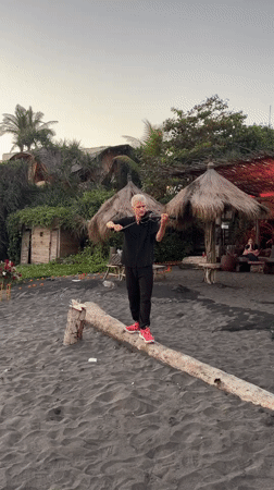 Violinist performs on log at Indonesian beach