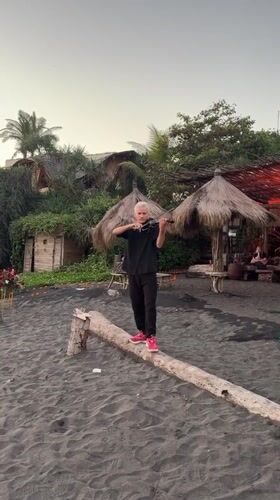 Violinist performs on log at Indonesian beach