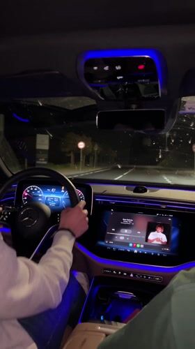 Car interior with blue ambient lighting filmed at night
