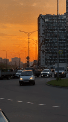 Sunset illuminates busy street scene in Kudrovo, Russia
