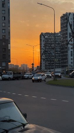 Sunset illuminates busy street scene in Kudrovo, Russia