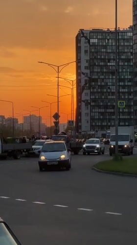 Sunset illuminates busy street scene in Kudrovo, Russia