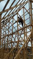 Construction worker builds wooden structure in Agbarha-Otor, Nigeria