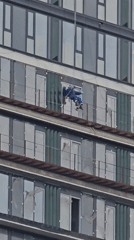 Building maintenance workers perform rope work on Moscow high-rise