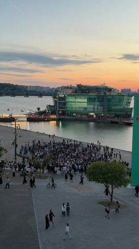 Evening crowds gather at Seoul waterfront during colorful sunset