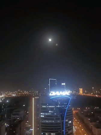 Dubai nighttime cityscape captured across multiple locations under full moon
