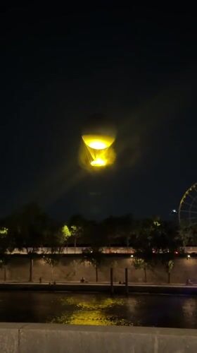 Hot air balloon glows over the Seine on a Paris night
