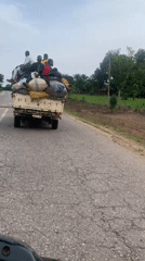 Loaded truck carries passengers on damaged road in Nigeria