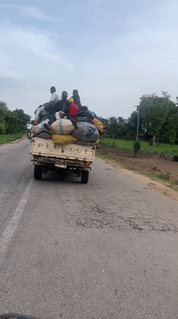 Loaded truck carries passengers on damaged road in Nigeria