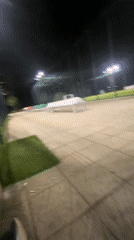 Person with soccer ball sits by illuminated field in Burgas