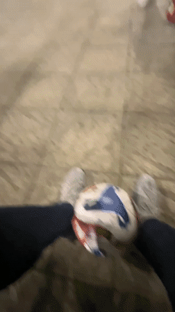 Person with soccer ball sits by illuminated field in Burgas