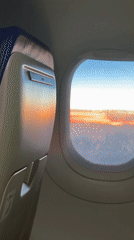 Passenger captures sunset view from airplane window over Italy