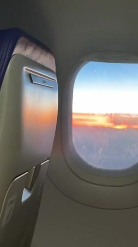 Passenger captures sunset view from airplane window over Italy