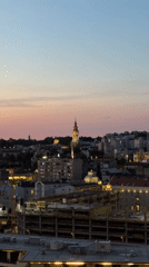 Belgrade sunset illuminates cathedral spire in evening cityscape