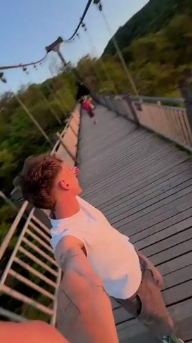 Young man takes selfie on wooden bridge in Yongding District