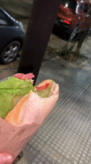 Man eats sandwich in Buenos Aires evening