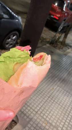 Man eats sandwich in Buenos Aires evening