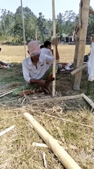 Outdoor event setup underway on a dry field in Klungkung