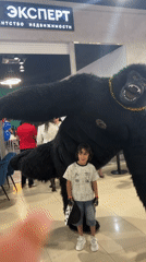Child poses with costumed performer in Russian indoor venue