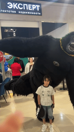 Child poses with costumed performer in Russian indoor venue
