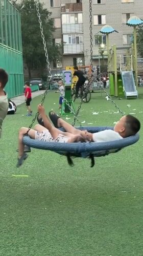 Evening in an Astana neighborhood — playgrounds, bikes, and a dusk sky