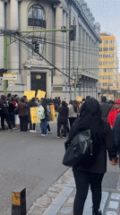 Daytime street protest with yellow signs in La Paz