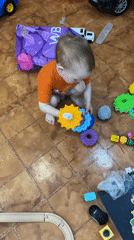 Toddler plays with toys on floor in Ferma, Russia