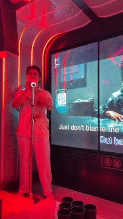 KTV session in a neon-lit karaoke room, Haizhu District