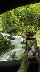 Tourist documents Lake Ritsa scenery and forest stream in Abkhazia