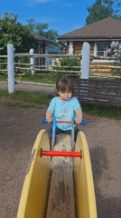 Toddler plays at Peterhof playground amid traditional Russian architecture