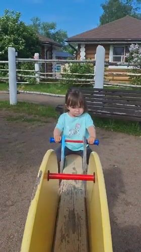 Toddler plays at Peterhof playground amid traditional Russian architecture