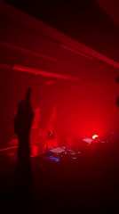 Late-night DJ set in a London club, red lights and fog