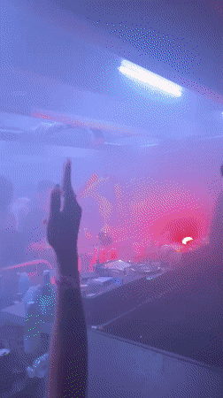 Late-night DJ set in a London club, red lights and fog
