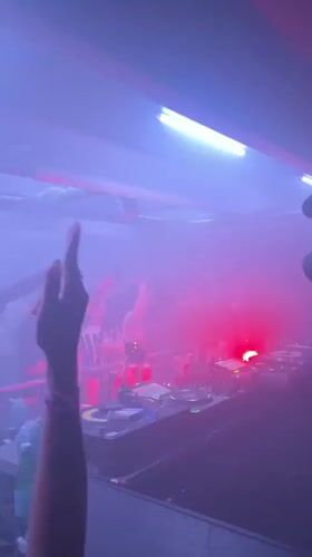 Late-night DJ set in a London club, red lights and fog