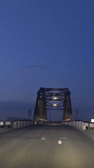 Driver records twilight bridge crossing in Chervlenoe, Russia
