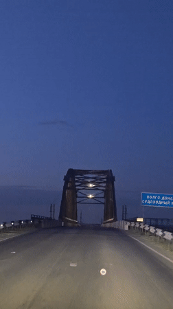 Driver records twilight bridge crossing in Chervlenoe, Russia