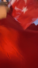 Crowd holds Turkish flag during evening gathering in Alanya